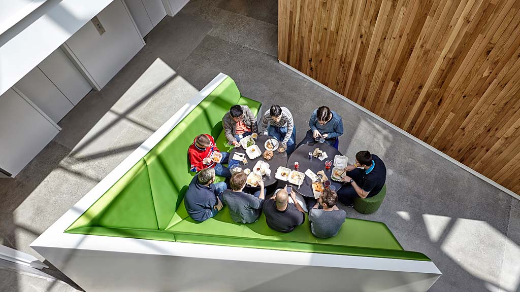 A group of people sitting on a green and white carpet.