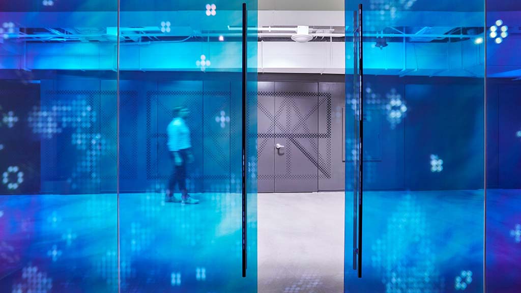 A person standing in a room with glass doors.