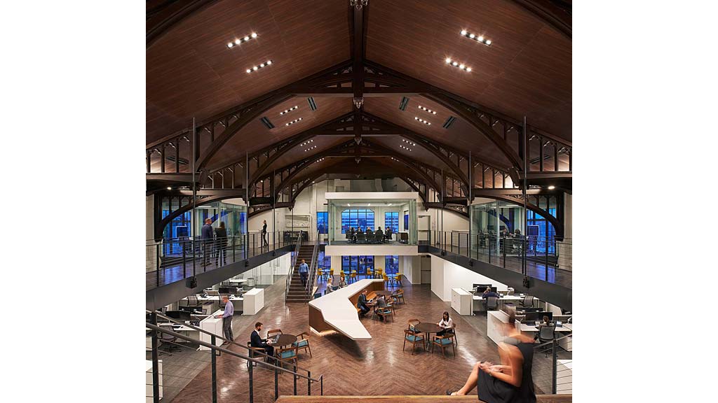 A group of people in a large room with a large staircase.