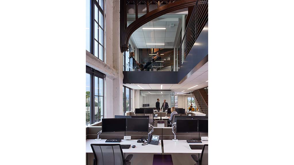 A room with a large mirror and a desk with computers.