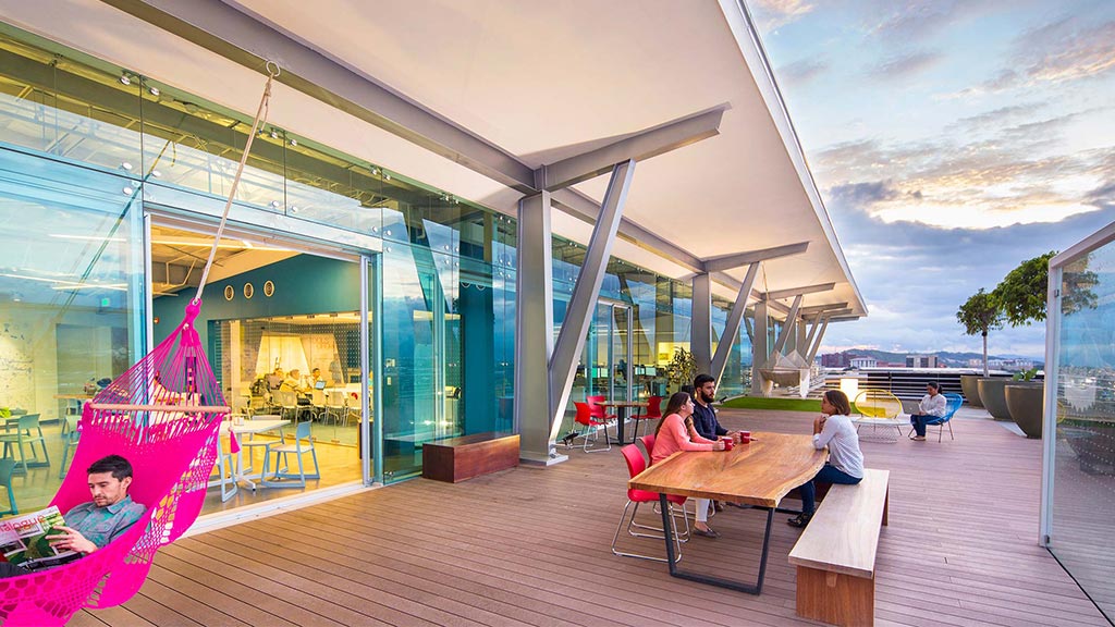 A group of people sitting at a table outside a building.