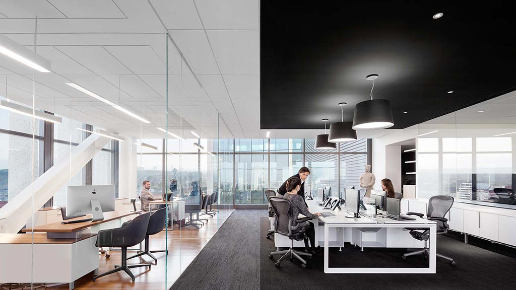 A group of people sitting at a table in a large office.