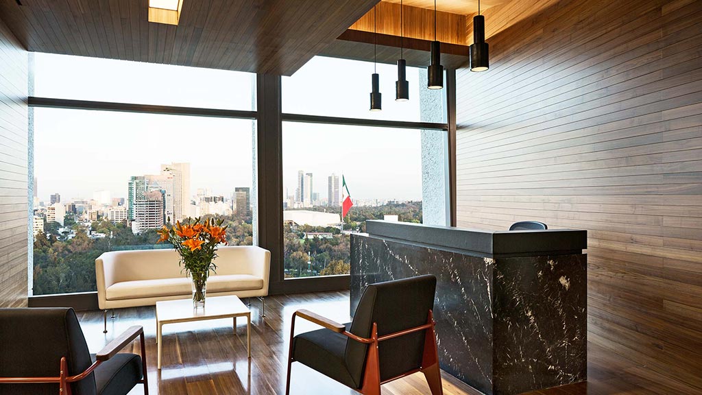 A room with a table chairs and a window with a view of a city.