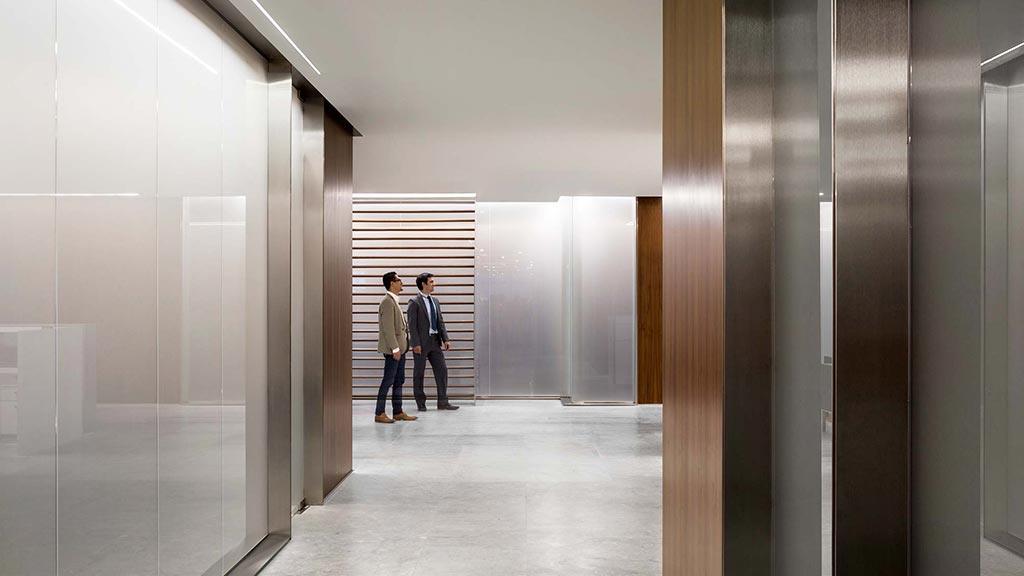 A couple of people walking in a hallway.