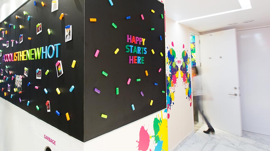 A large black board with colorful stickers on it.