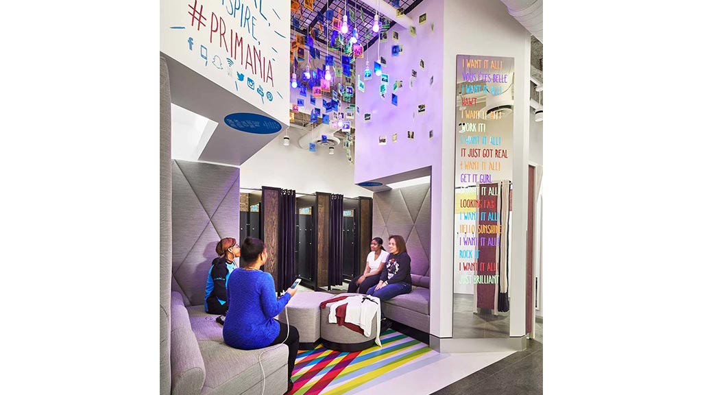 A group of people sitting on a couch in a room with a sign.
