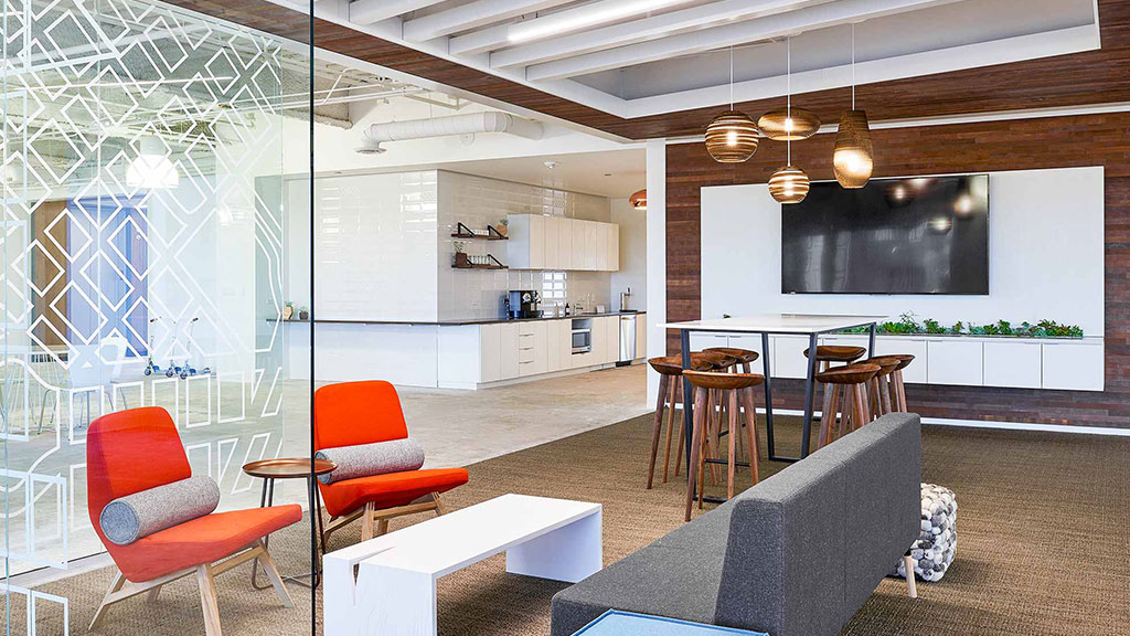 A room with a couch and chairs.