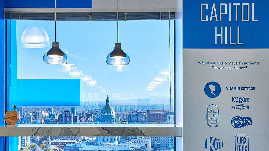 A window with a view of a city and a bell.