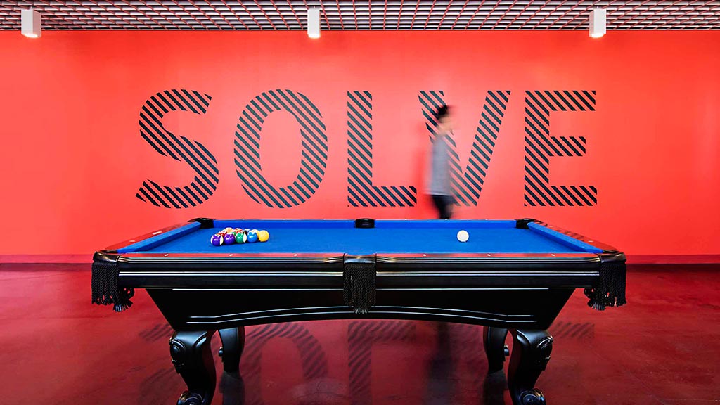 A pool table with a sign above it.