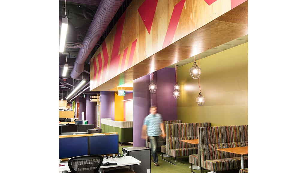 A person standing in a room with tables and chairs.