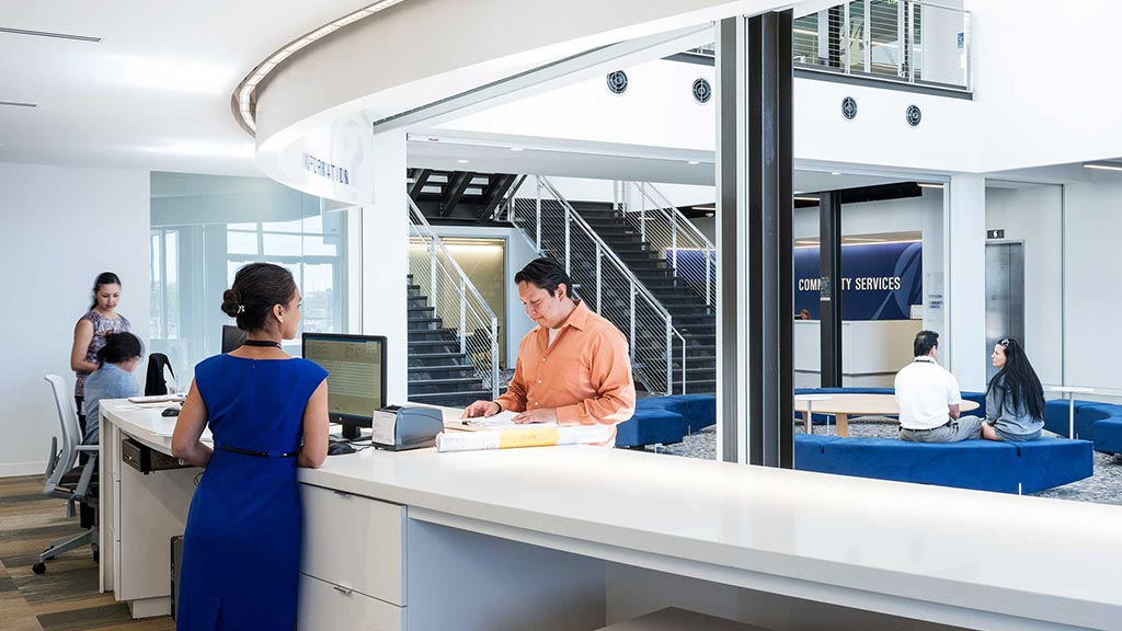 A woman and a man in a room with computers.