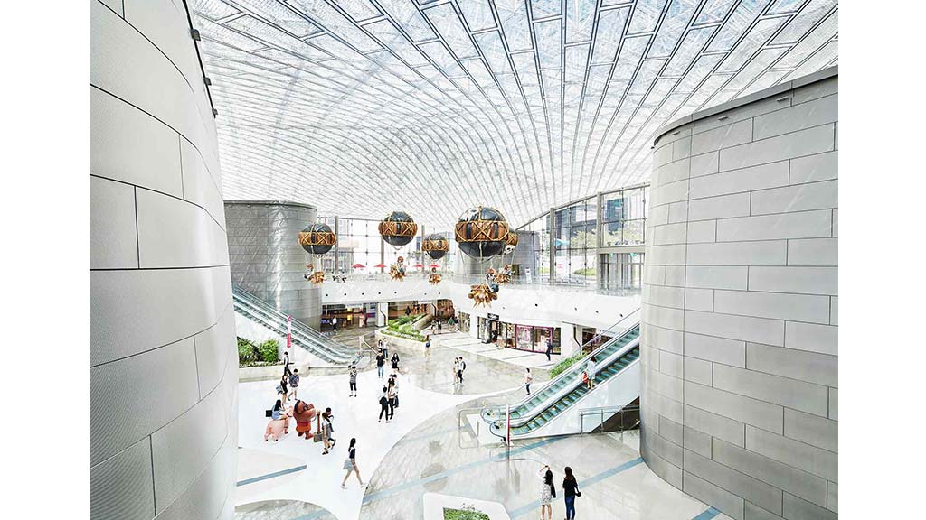 A group of people walking on a walkway between buildings.