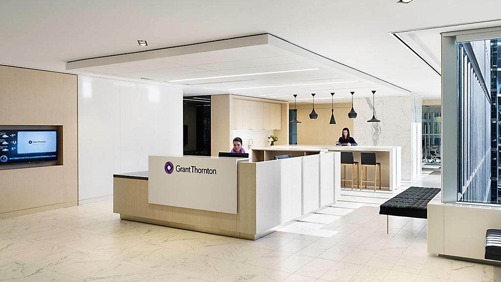 A couple of people sitting at a table in a large room.