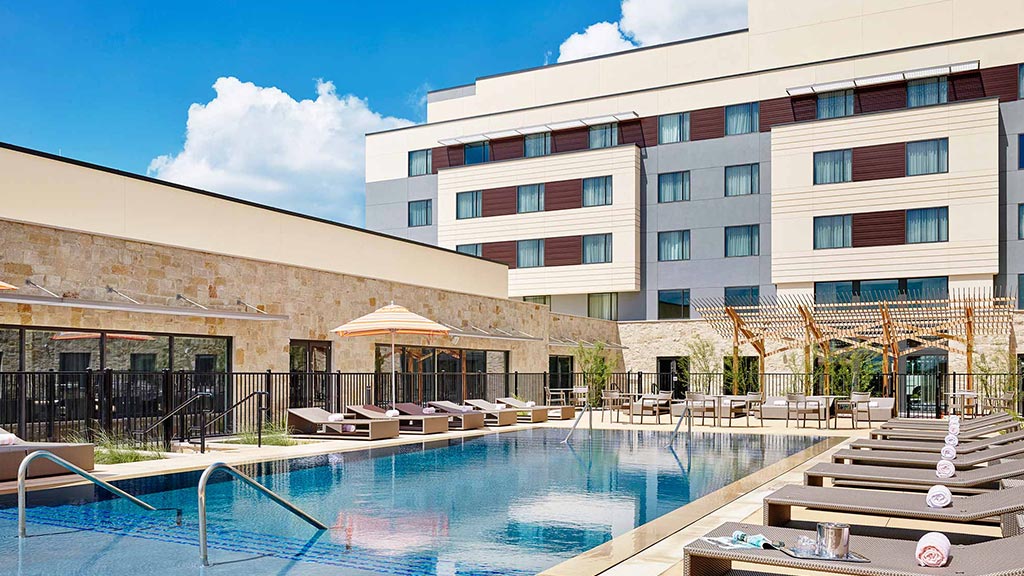 A swimming pool in front of a large building.