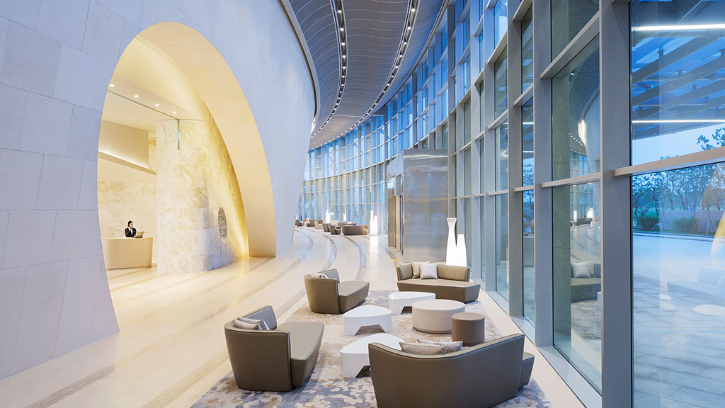 A room with a large glass wall and a large stone floor.