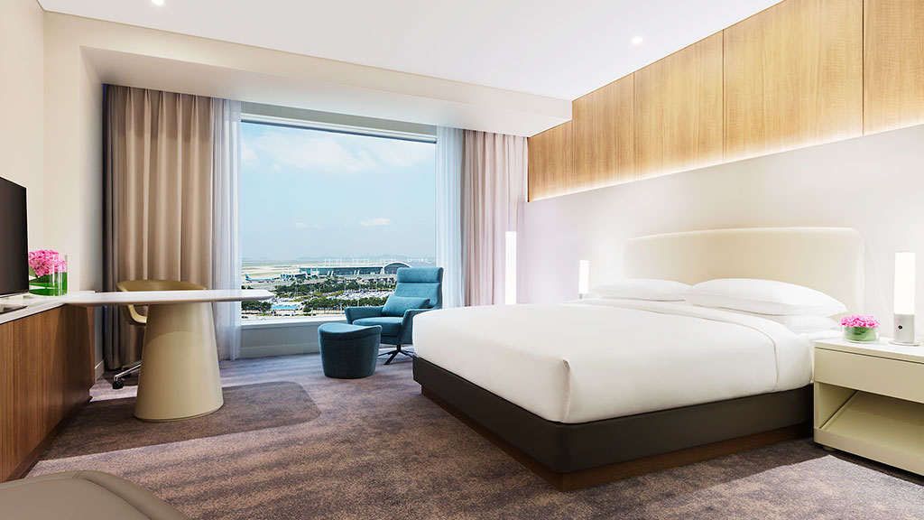 A bedroom with a large window.