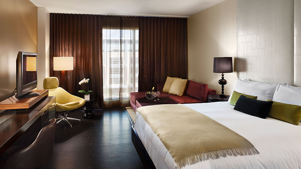 A hotel room with a bed and a tv.