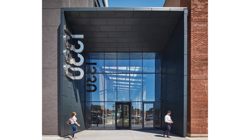 A couple of people walking outside of a building.