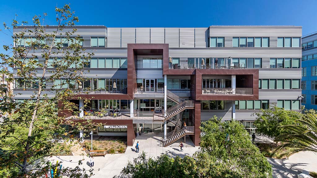A building with stairs and trees in front of it.