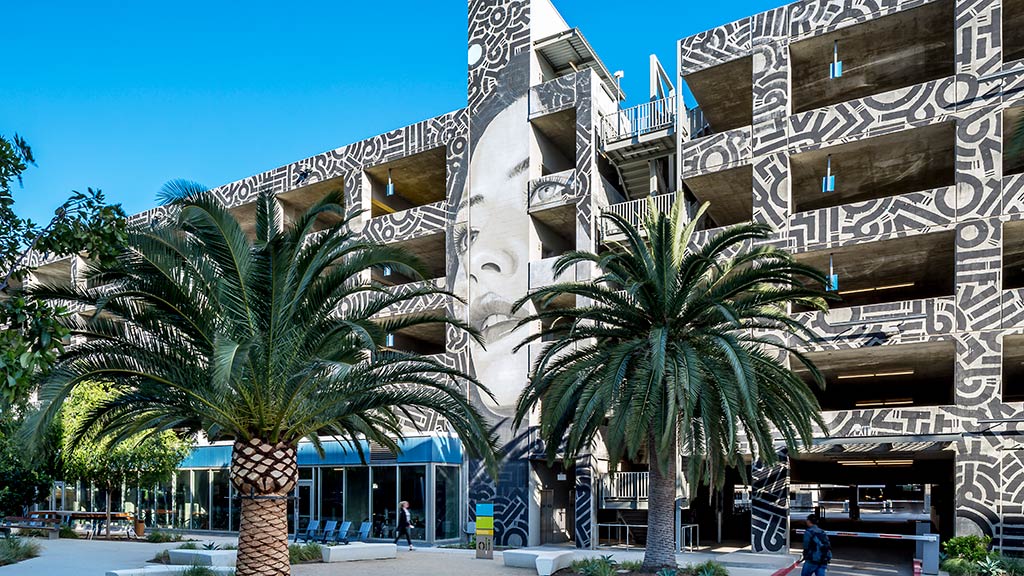 A building with palm trees in front of it.