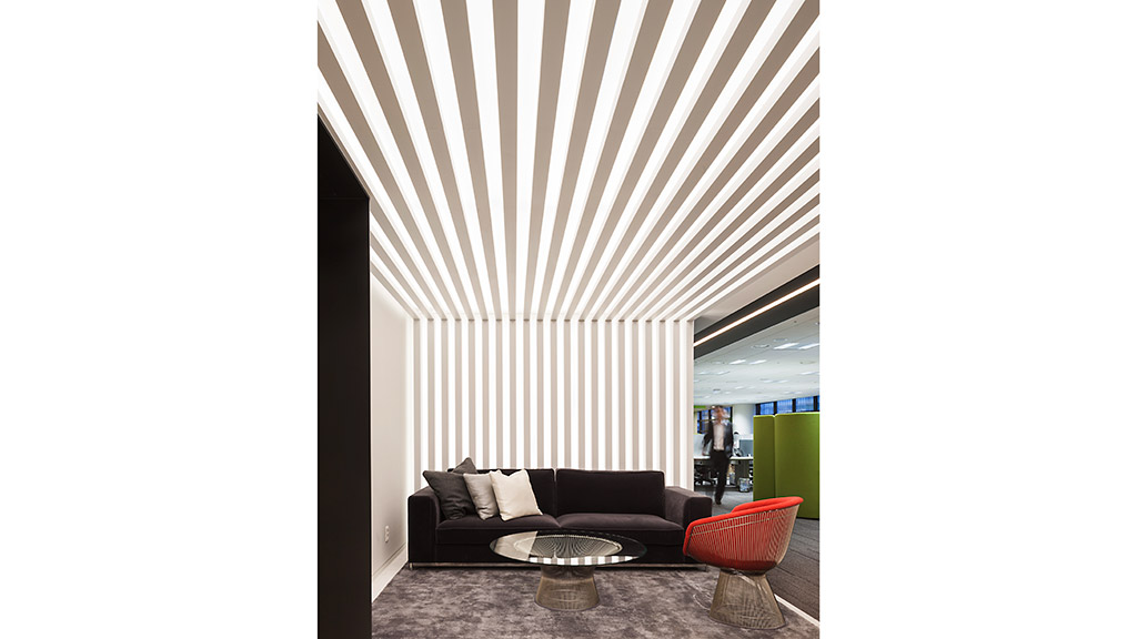 A couch and a table in a room with a ceiling fan.