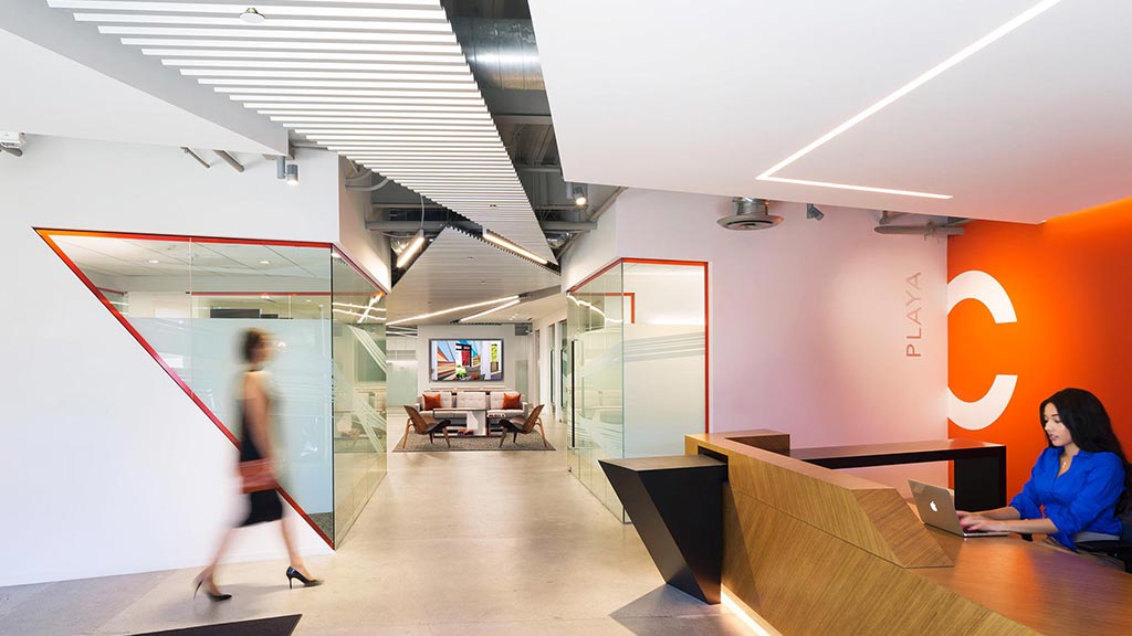 A person sitting on a bench in a room with a person standing.