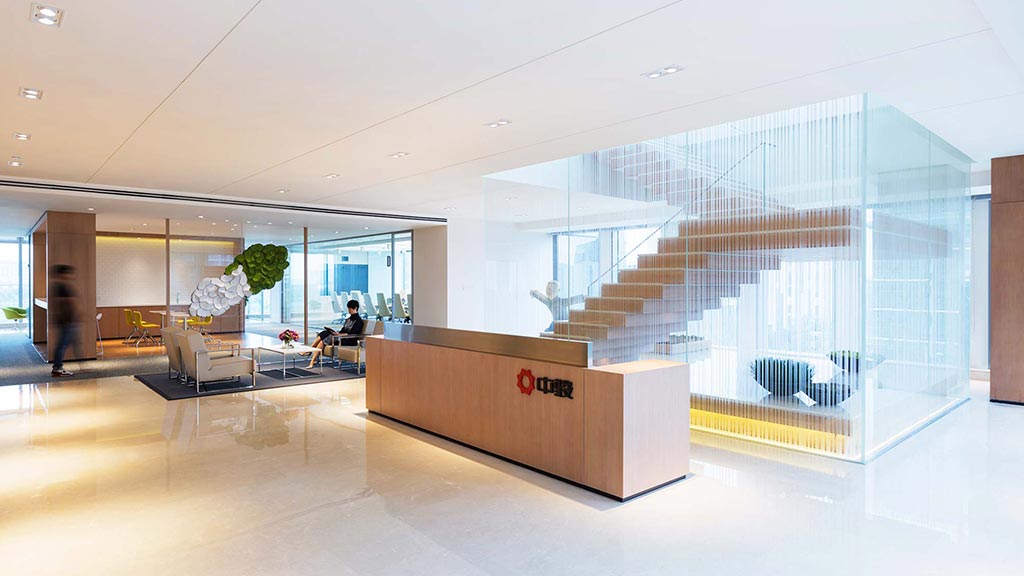 A large office building with a large glass wall.