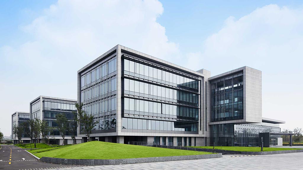 A modern building with a green lawn.