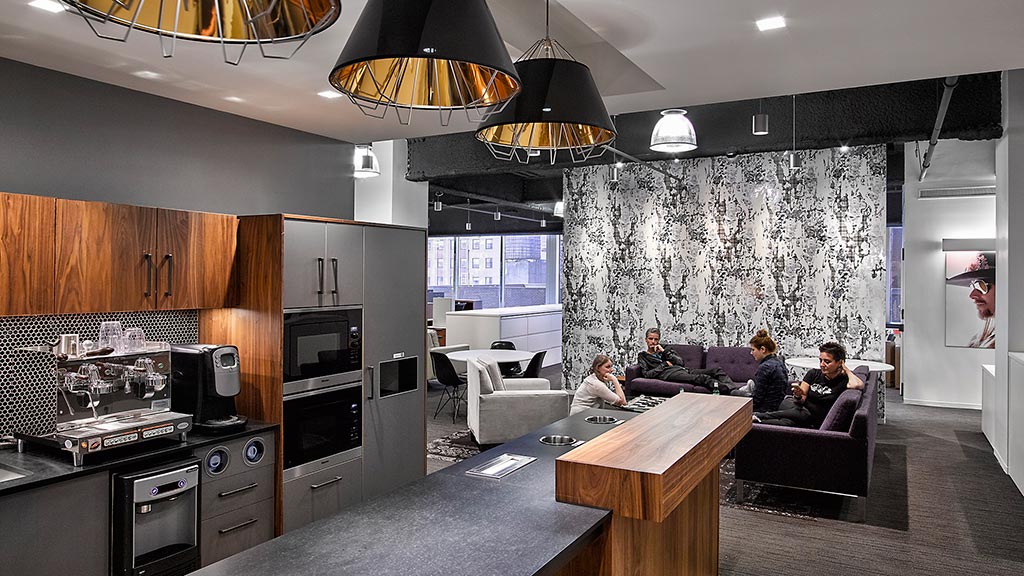 A group of people sitting in a kitchen.