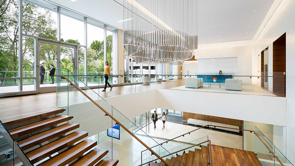 A large white room with a few people walking around.