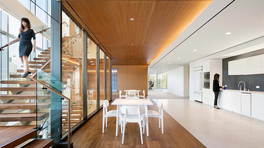 A man standing in a room with a table and chairs.