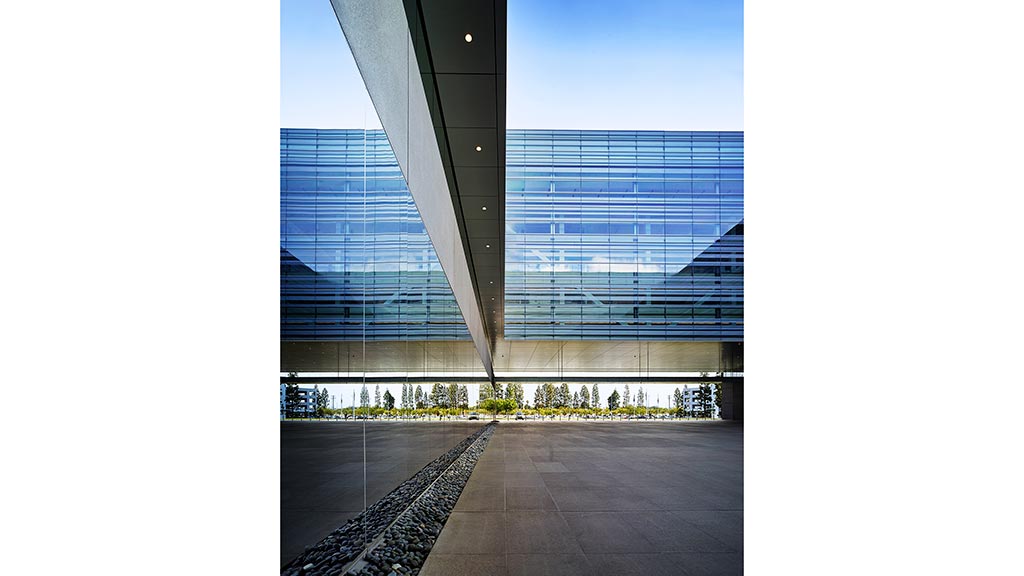 A large glass building with a train track.