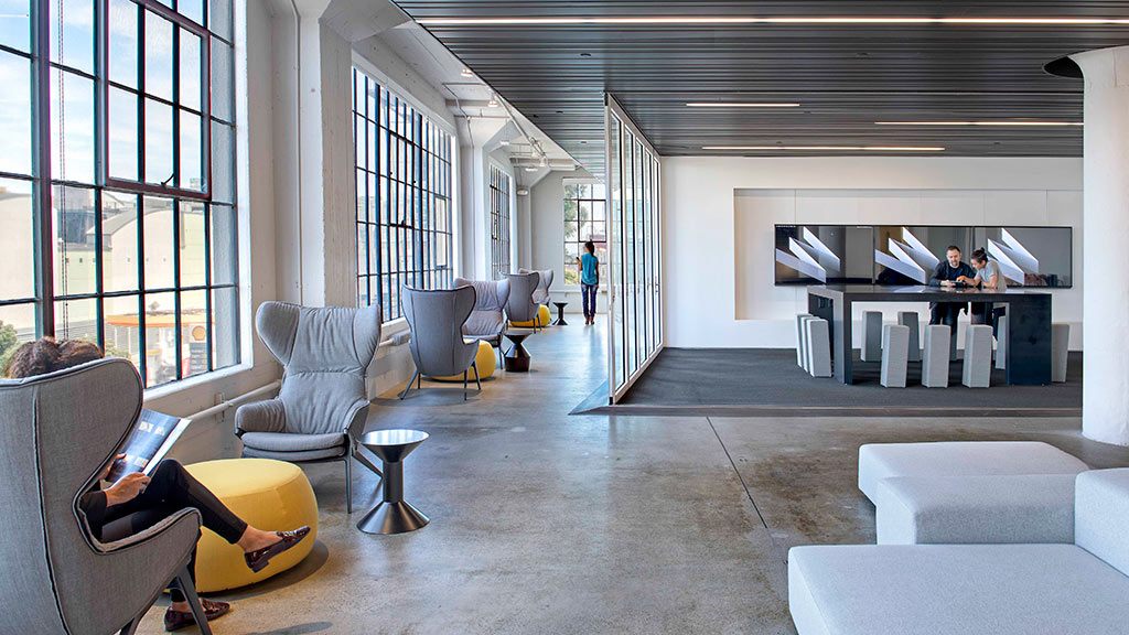 A room with a few people and a table and chairs.