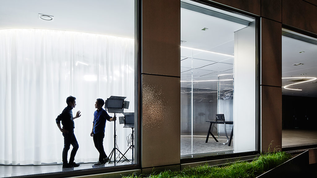 A few men standing in front of a glass door.