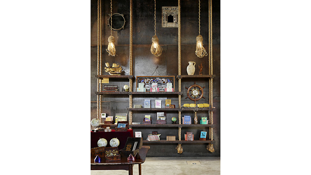 A room with a shelf full of books and a clock.
