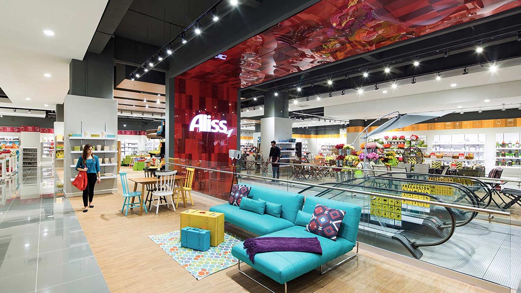 A mall with a blue couch and a person walking.