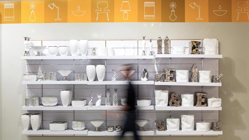 A person walking past a display of cups.