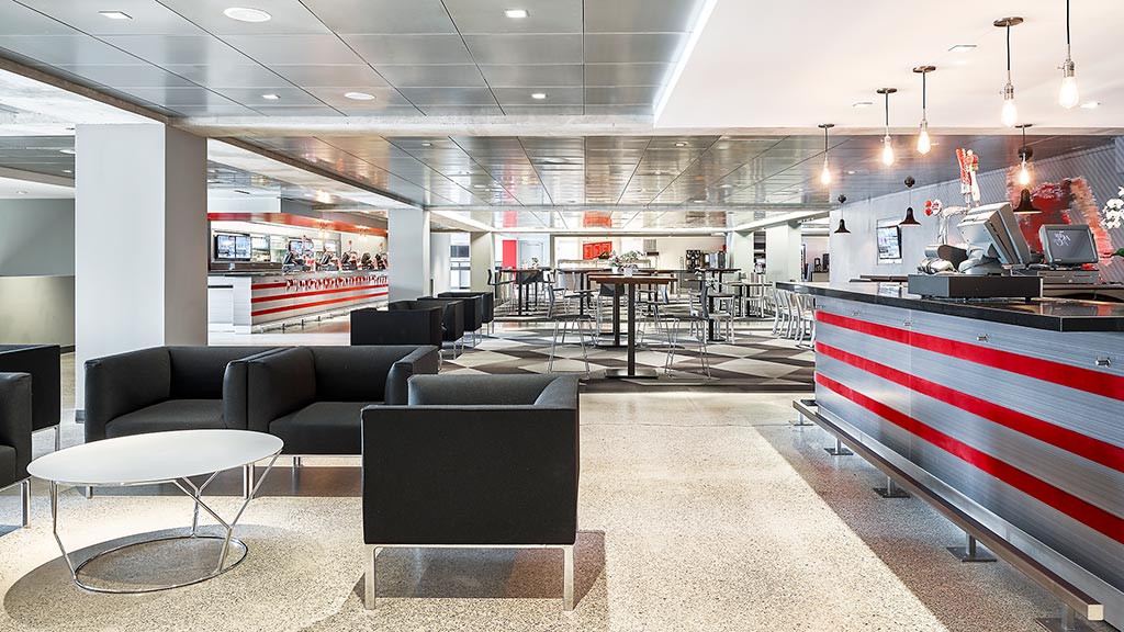 A large room with black couches and tables.