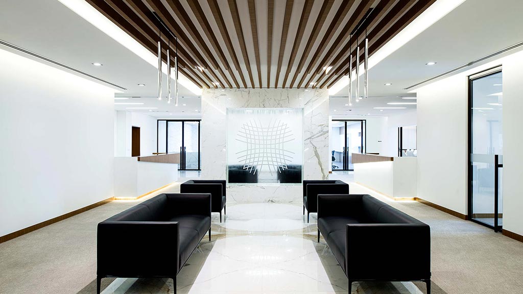 A room with black couches and white walls.