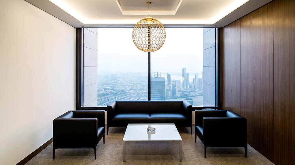 A room with a large window and a table with chairs in it.