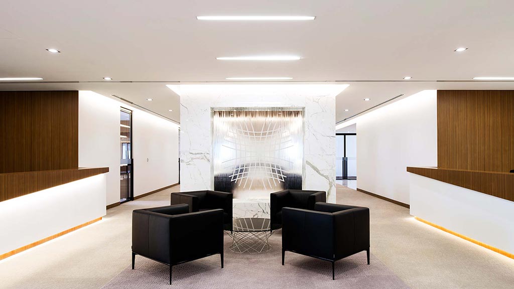 A room with black couches and a large window.