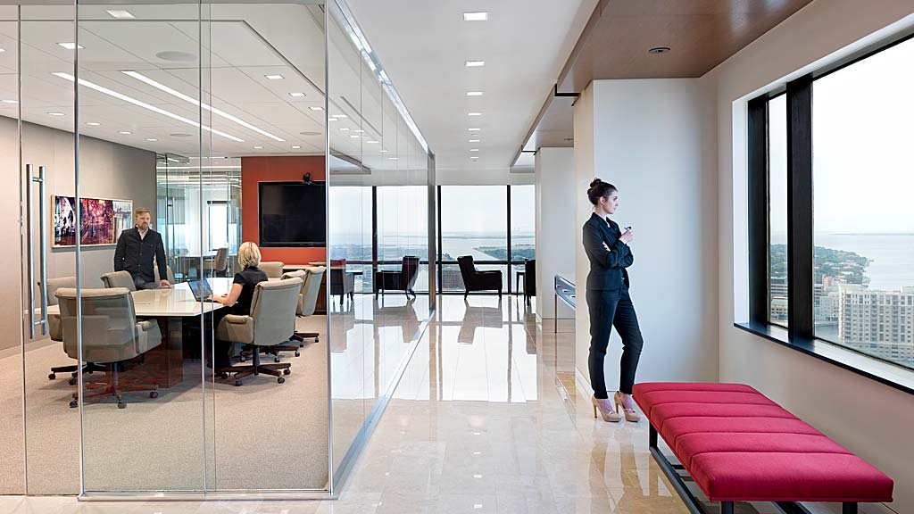 A person standing in a room with a table and chairs.