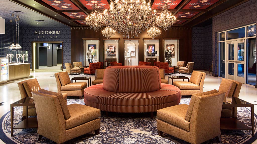 A room with a chandelier and chairs.