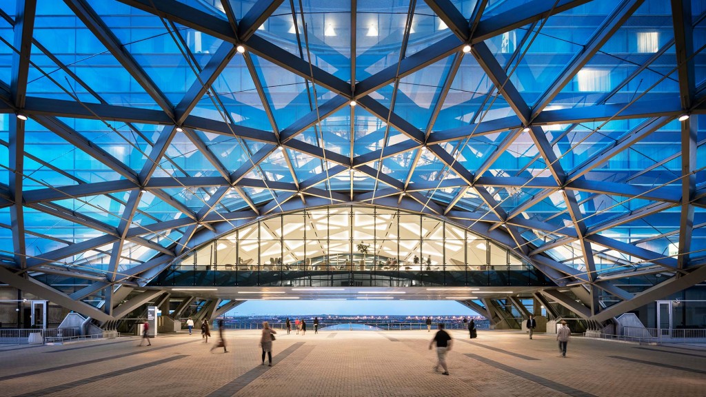 A large glass building with people walking around.