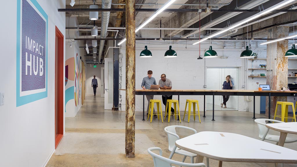 A group of people sitting at a table in a room with tables and chairs.