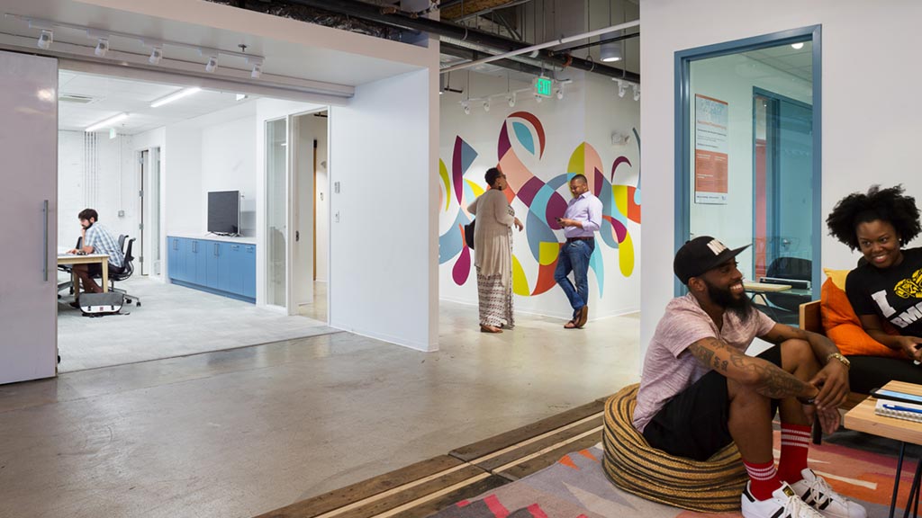 A group of people sitting in a room with a rug and a rug.