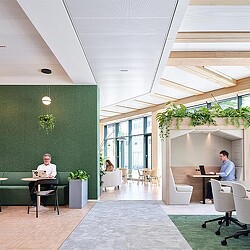 A man and a woman sitting at a table in a room with green walls.