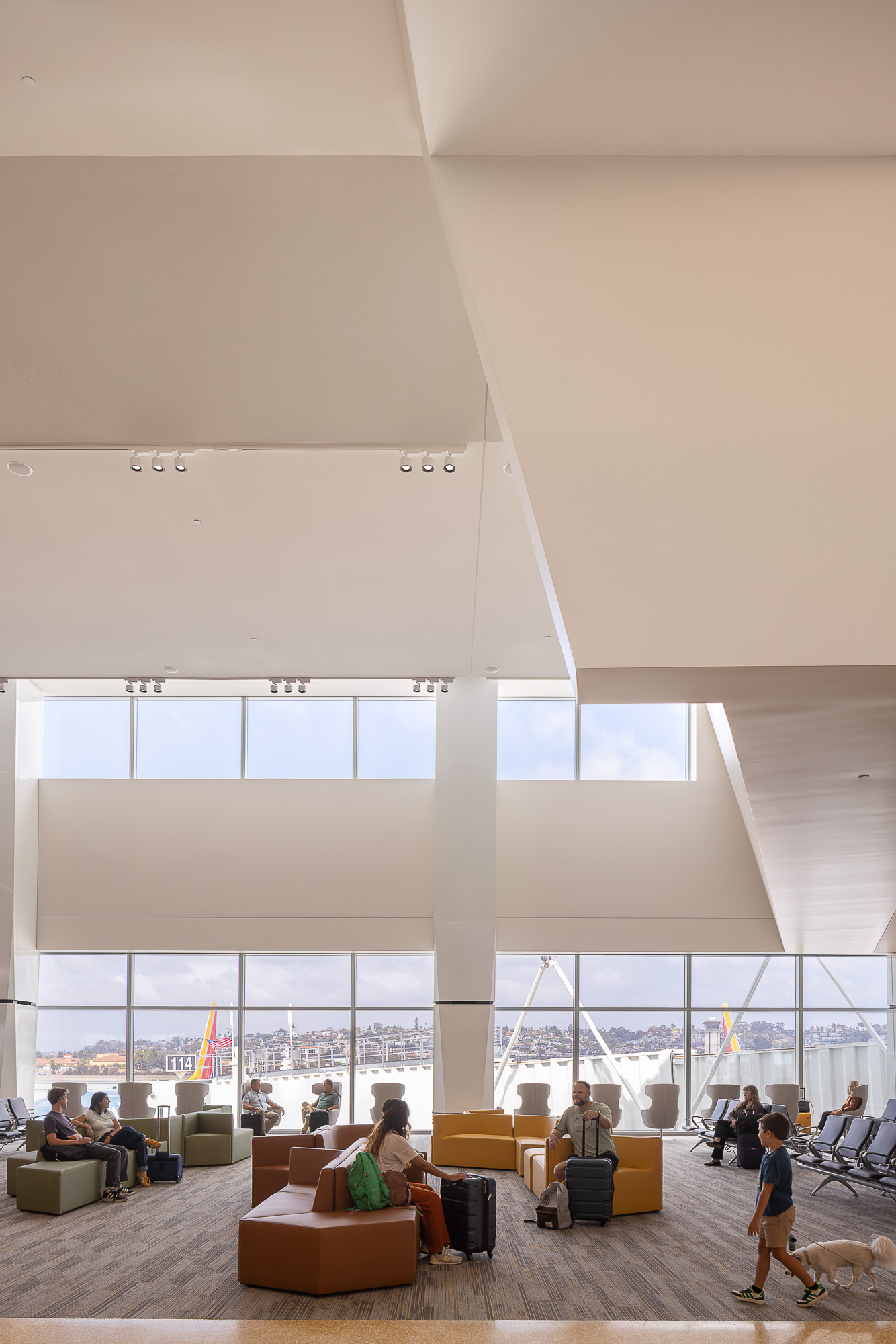 People sitting on couches in a large room with large windows.