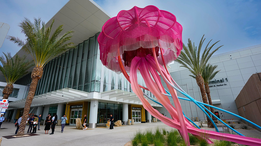 A large pink sculpture in front of a building.