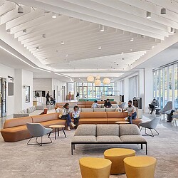 A group of people sitting in a room with a large ceiling.